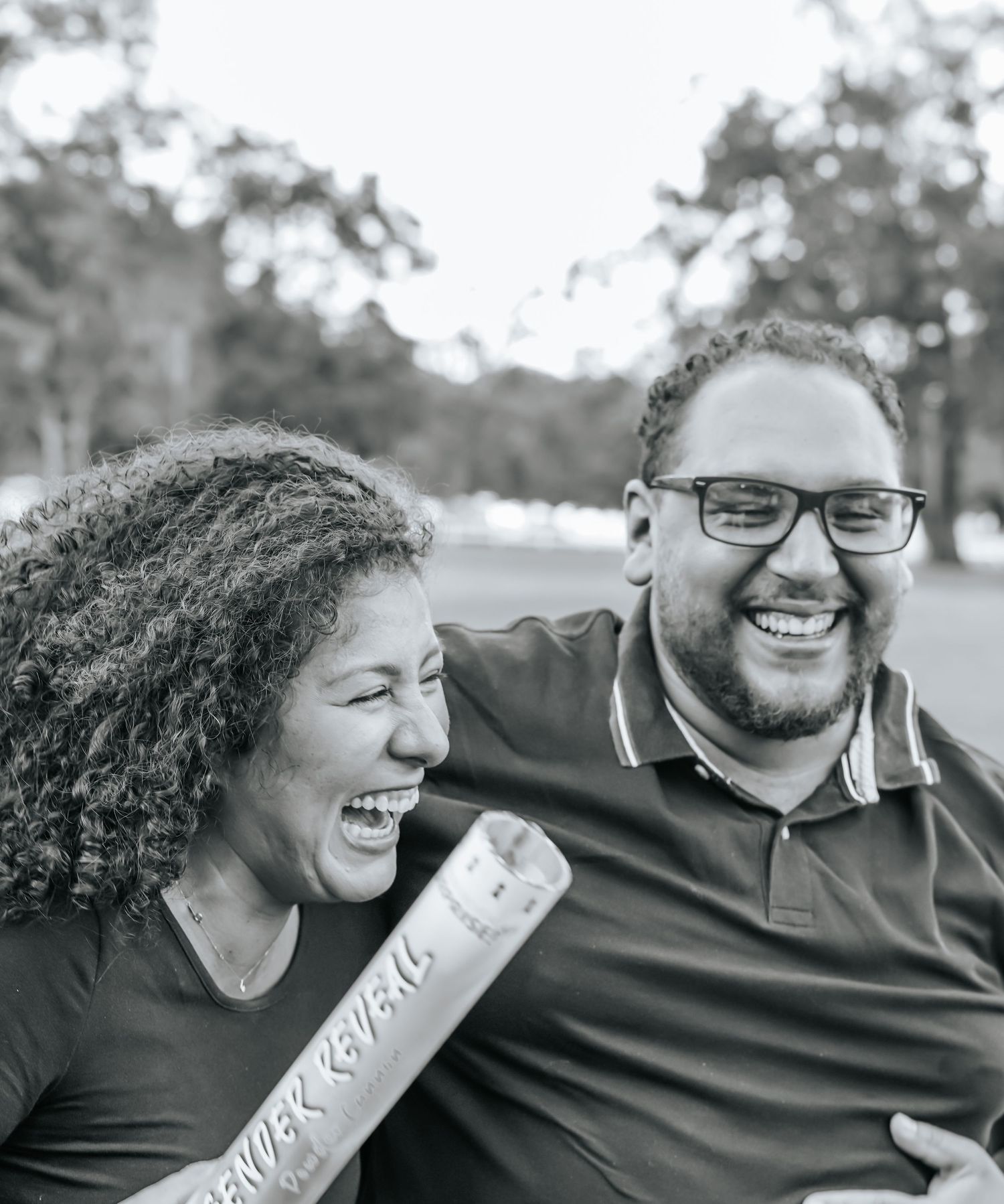 Couple laughing together during outdoor photo session in black and white.