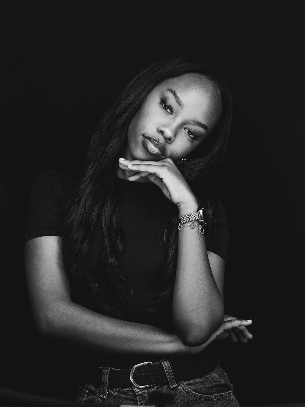 A dramatic black and white portrait series captured in moody lighting with expressive poses against a dark background.