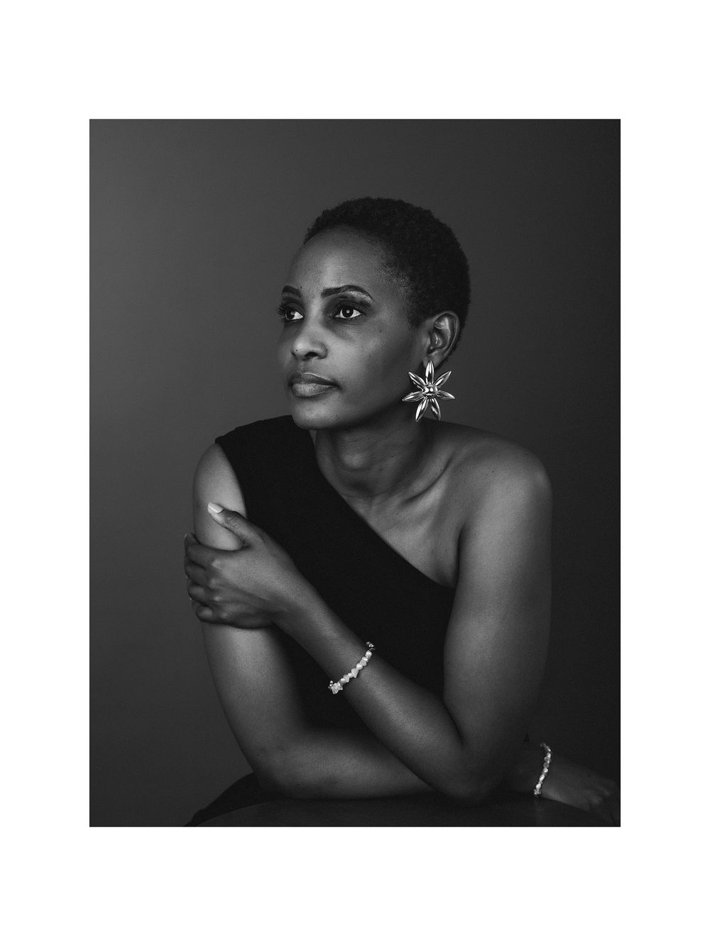 A series of black and white fashion portraits showing elegant poses against a dark dramatic background.