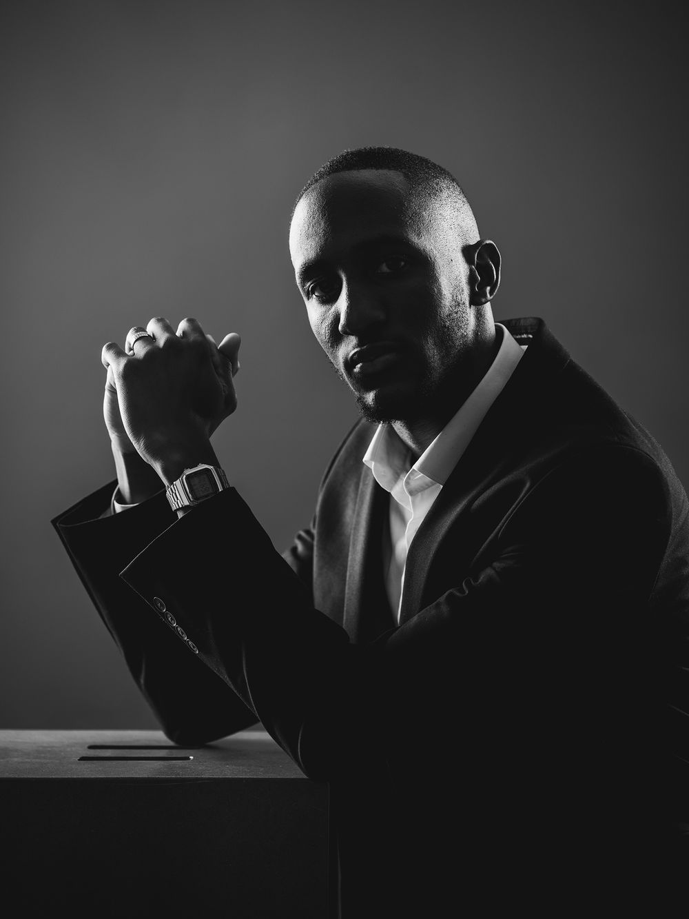 Five dramatic black and white portraits showing a contemplative figure in shadow against dark backgrounds.