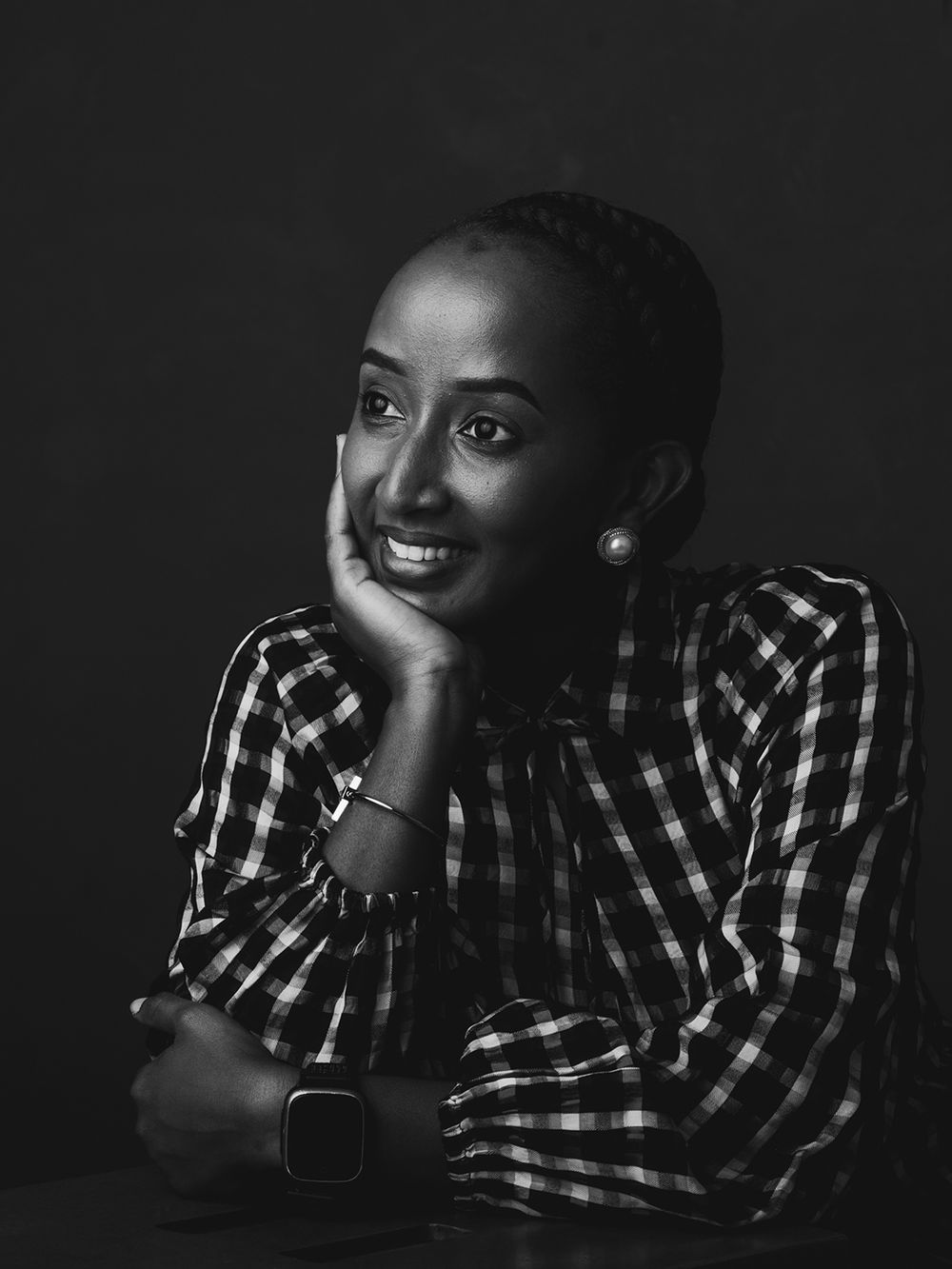 A dark and moody portrait series showing someone in a checkered shirt against black background with dramatic lighting.