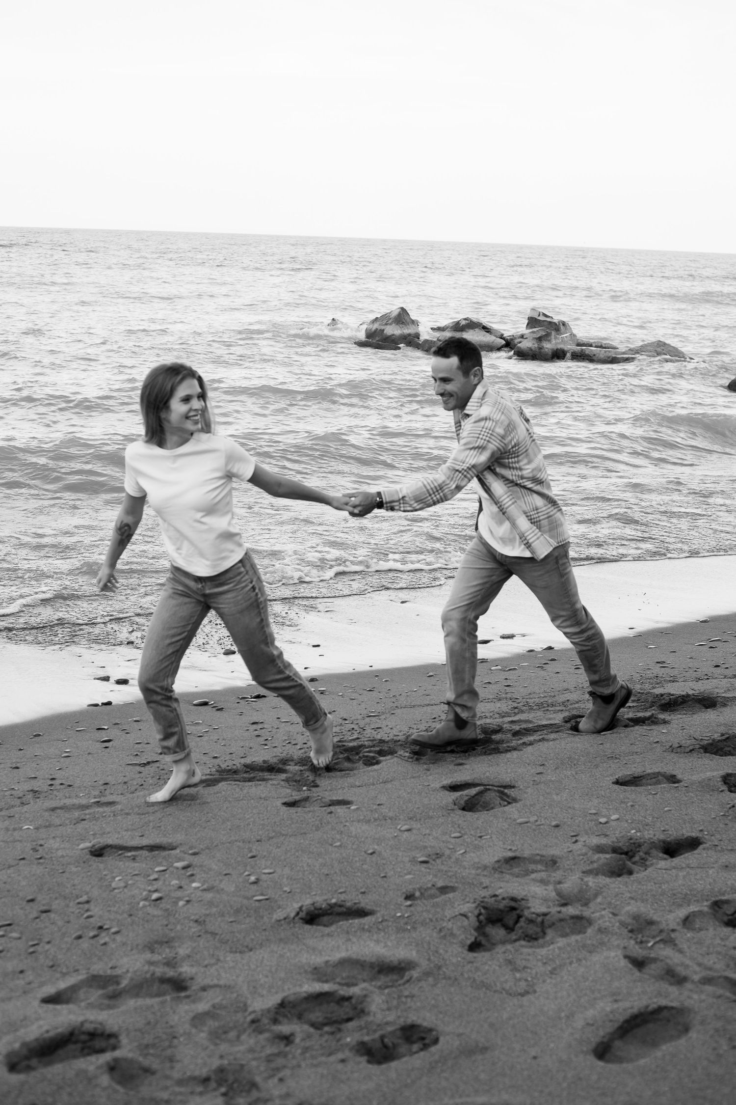 A couple running around enjoying themselves on the beach