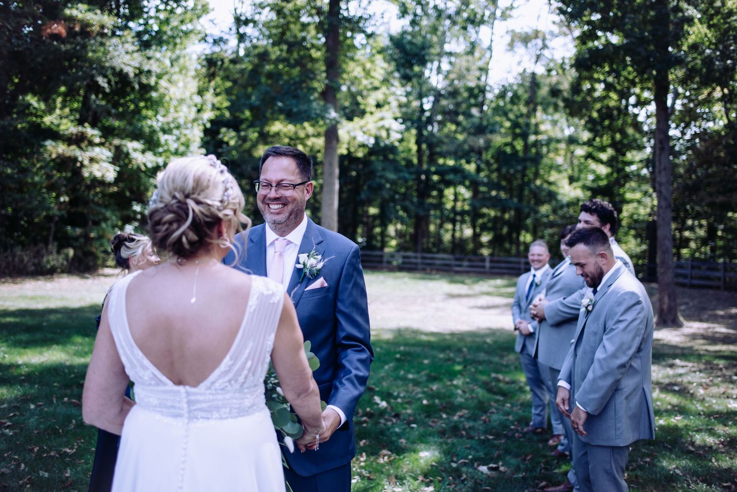 Wedding couple shares intimate moments in an outdoor wooded setting.