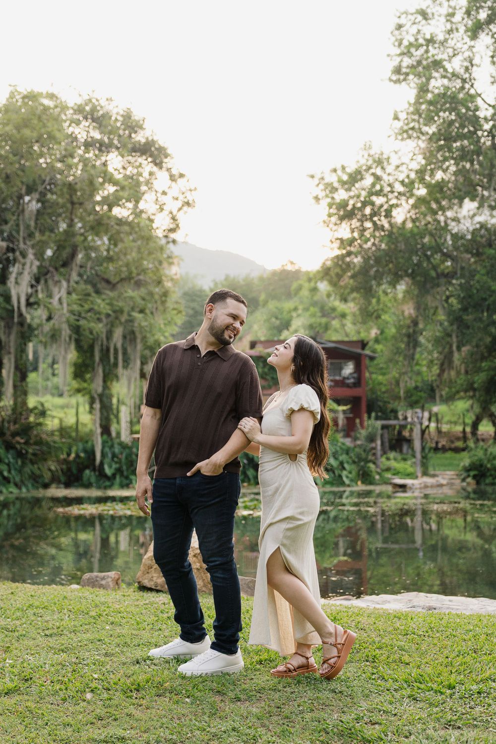 Couple shares intimate moments by a serene lake during a golden hour photoshoot.