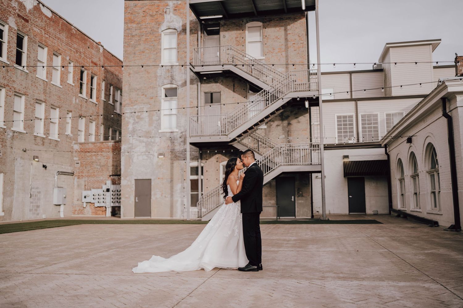 Wedding couple sharing romantic moment on white porch railing.