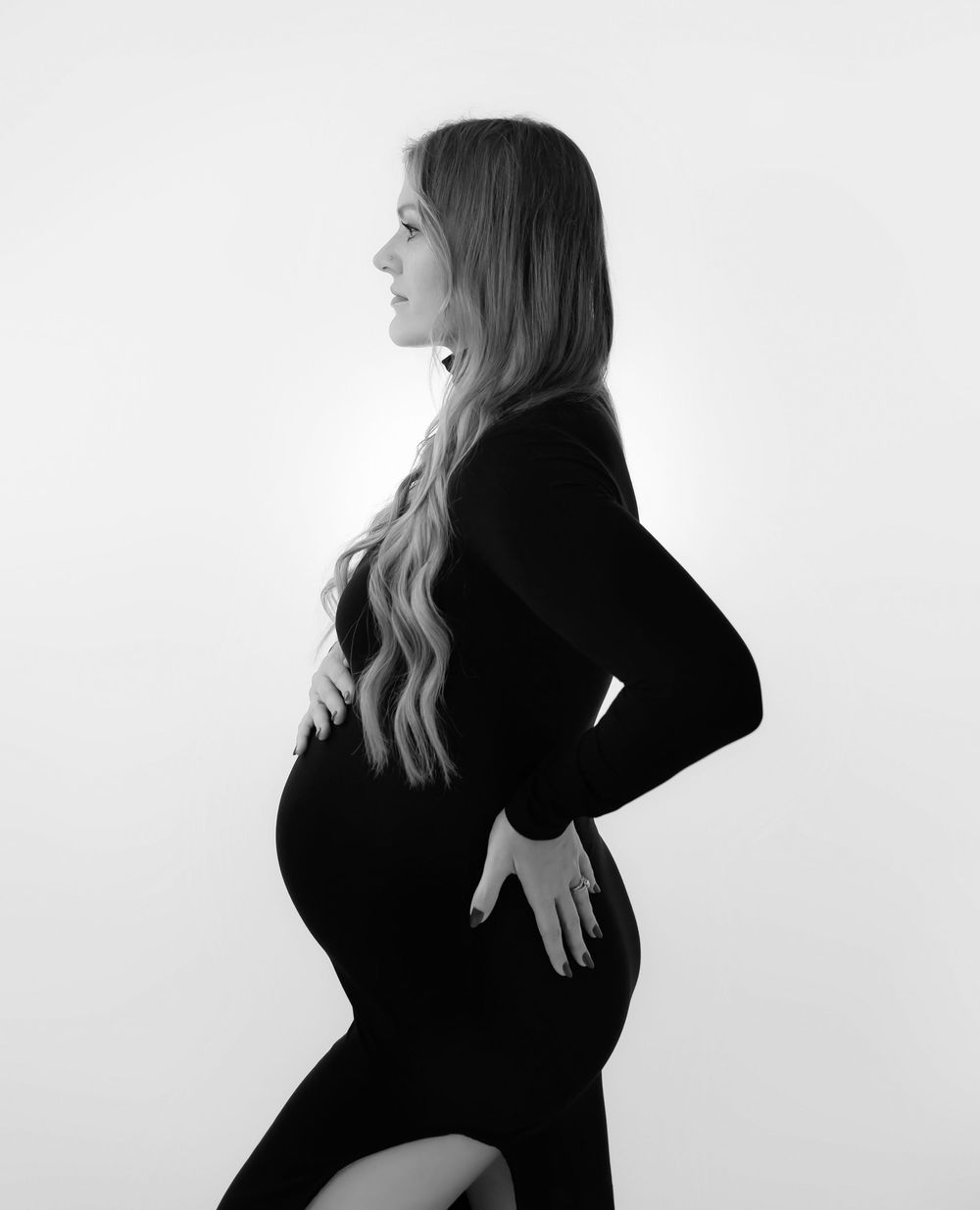 Artistic black and white maternity portraits against minimalist white background.