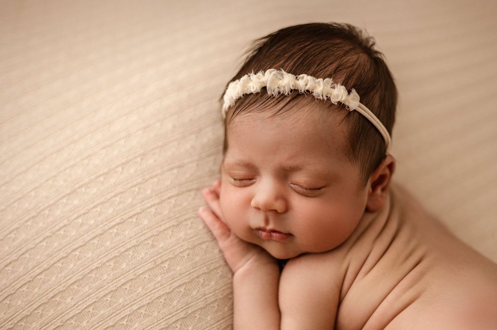 Newborn baby posed on soft blue backdrop during studio newborn session in Magnolia TX