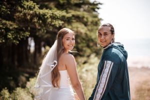 A couple pose together on a scenic mountain trail with trees and a blurred landscape in the background. Photo at Charlottetown PEI