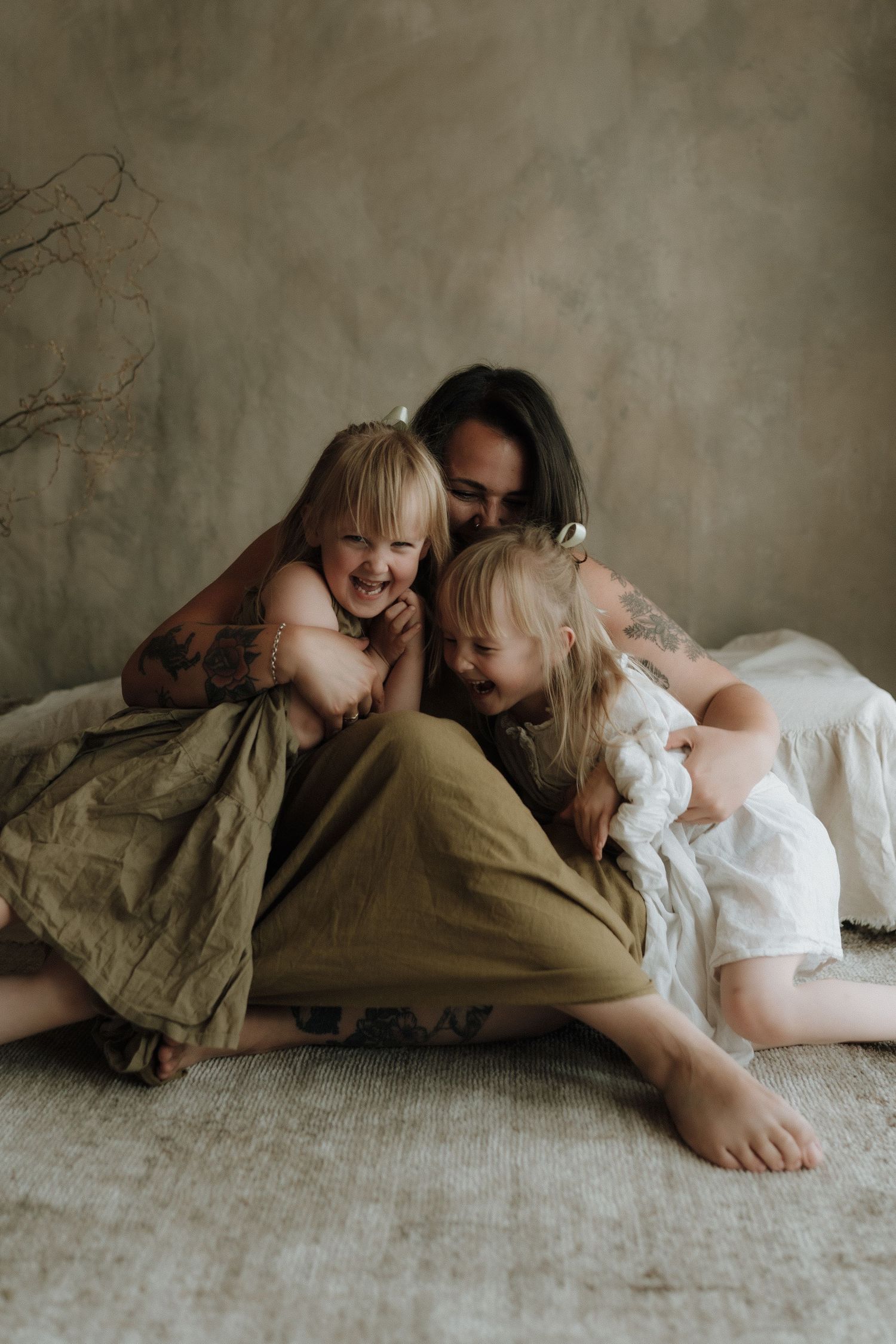An intimate family moment showing playful cuddles and laughter on a cozy blanket.