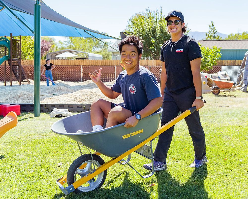 Orange Lutheran High School students using wheel barrel in Bishop California on a mission trip to help rebuild school playground equipment