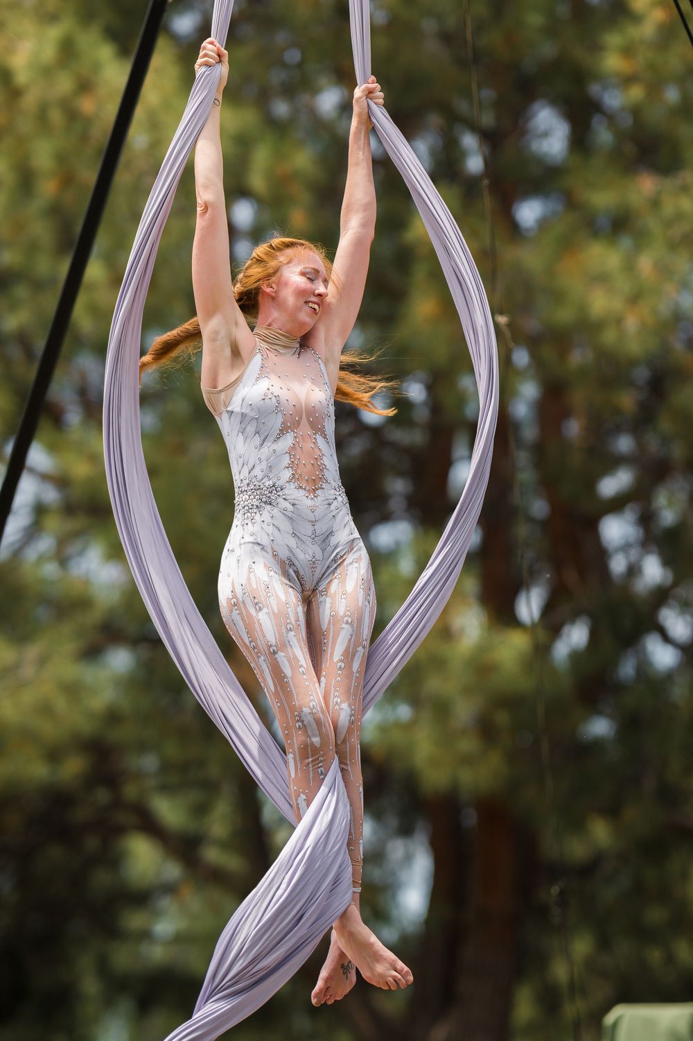 Silk aerialist performs mid-routine in a flowing costume at a Renaissance Faire, captured by Chris Cornish Photography.