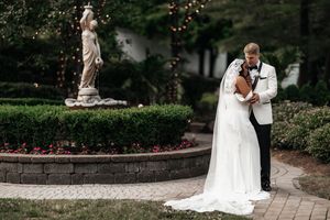 A romantic wedding couple embraces in a lush garden setting during their outdoor photo session.
