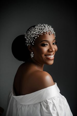 Portrait series of a bride wearing a white off-shoulder dress and crystal hair accessories against a dark background.