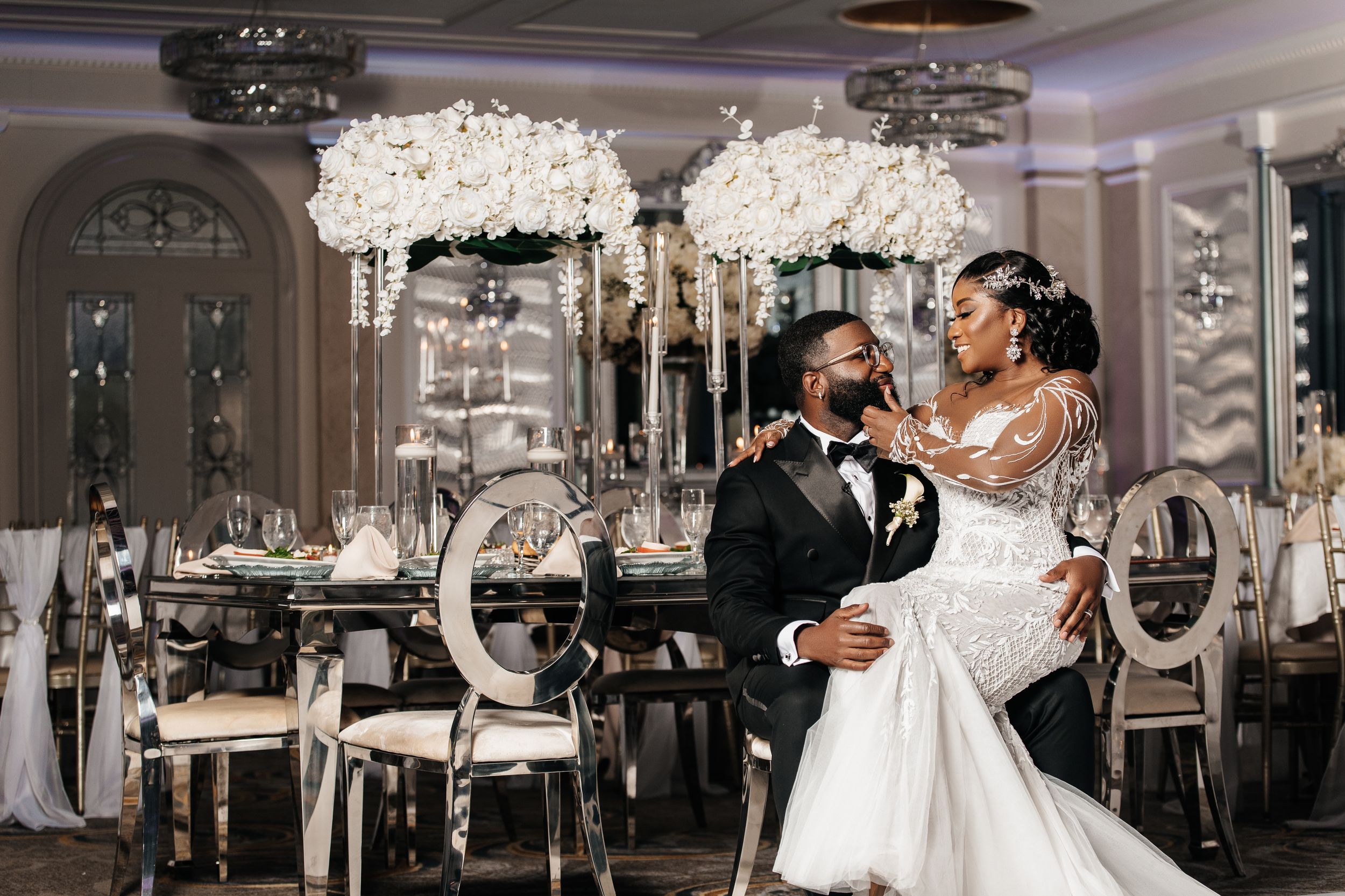 Elegant wedding reception celebration in a luxurious ballroom with crystal chandeliers and ornate decor.