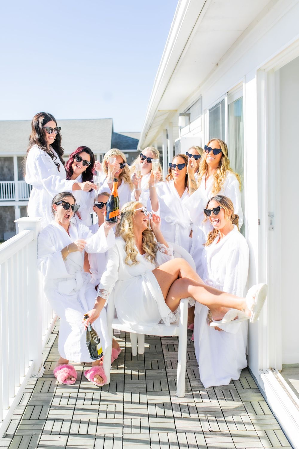 Bridal party and bride wearing fun glasses on a balcony before the wedding