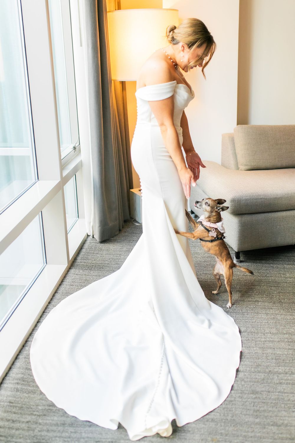 Bride reaching down to pet her dog