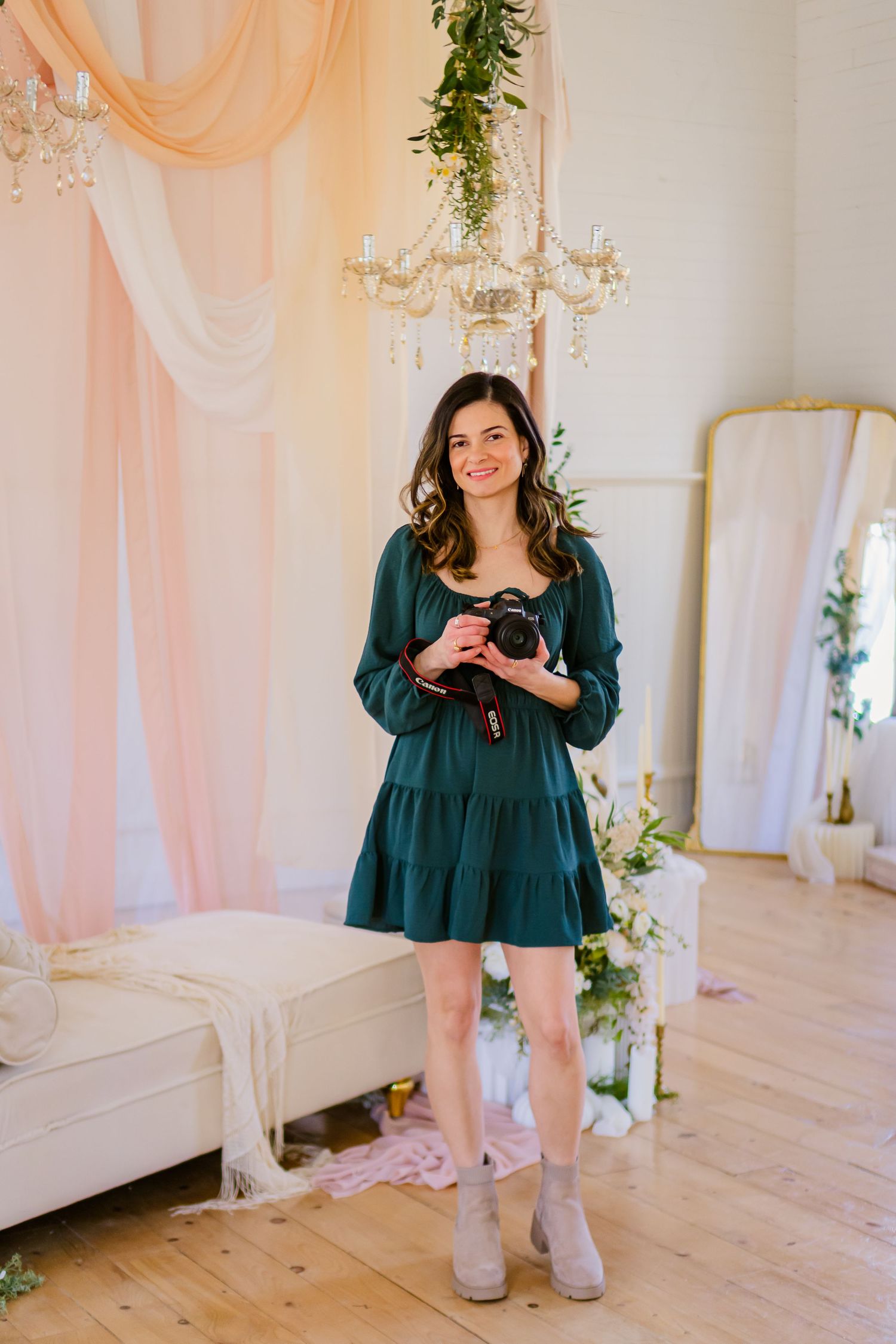 Photographer holding a camera, studio session, green dress