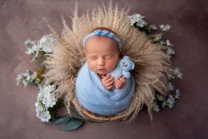 Newborn baby wrapped in soft blanket, sleeping peacefully in Wolverhampton studio