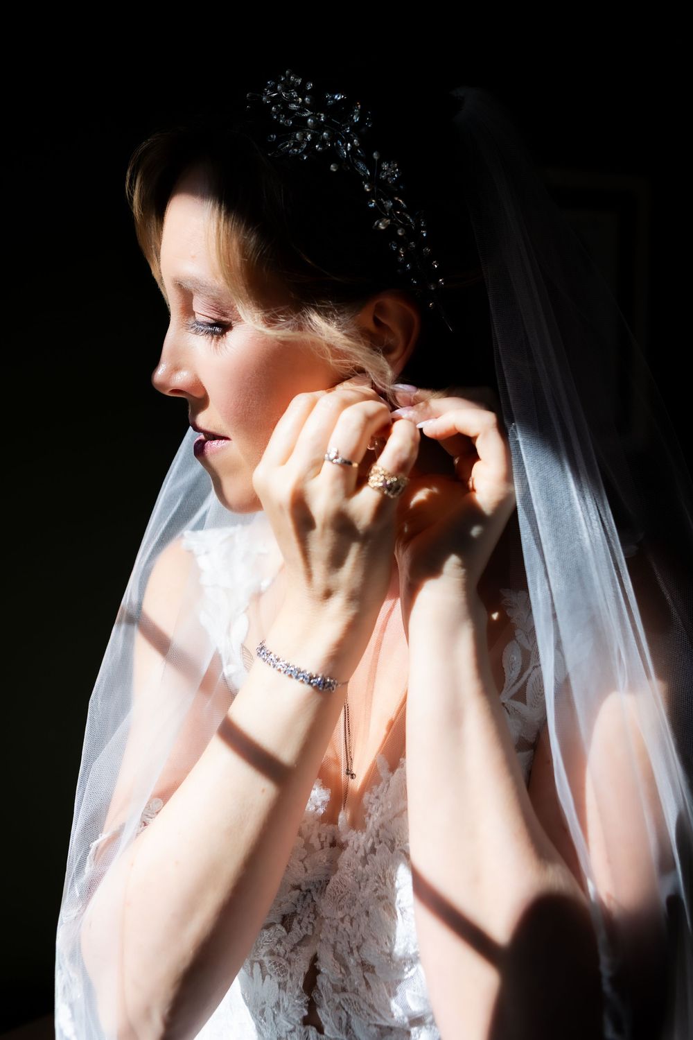 A series of artistic bridal portraits showing someone adjusting a delicate white veil in dramatic lighting.