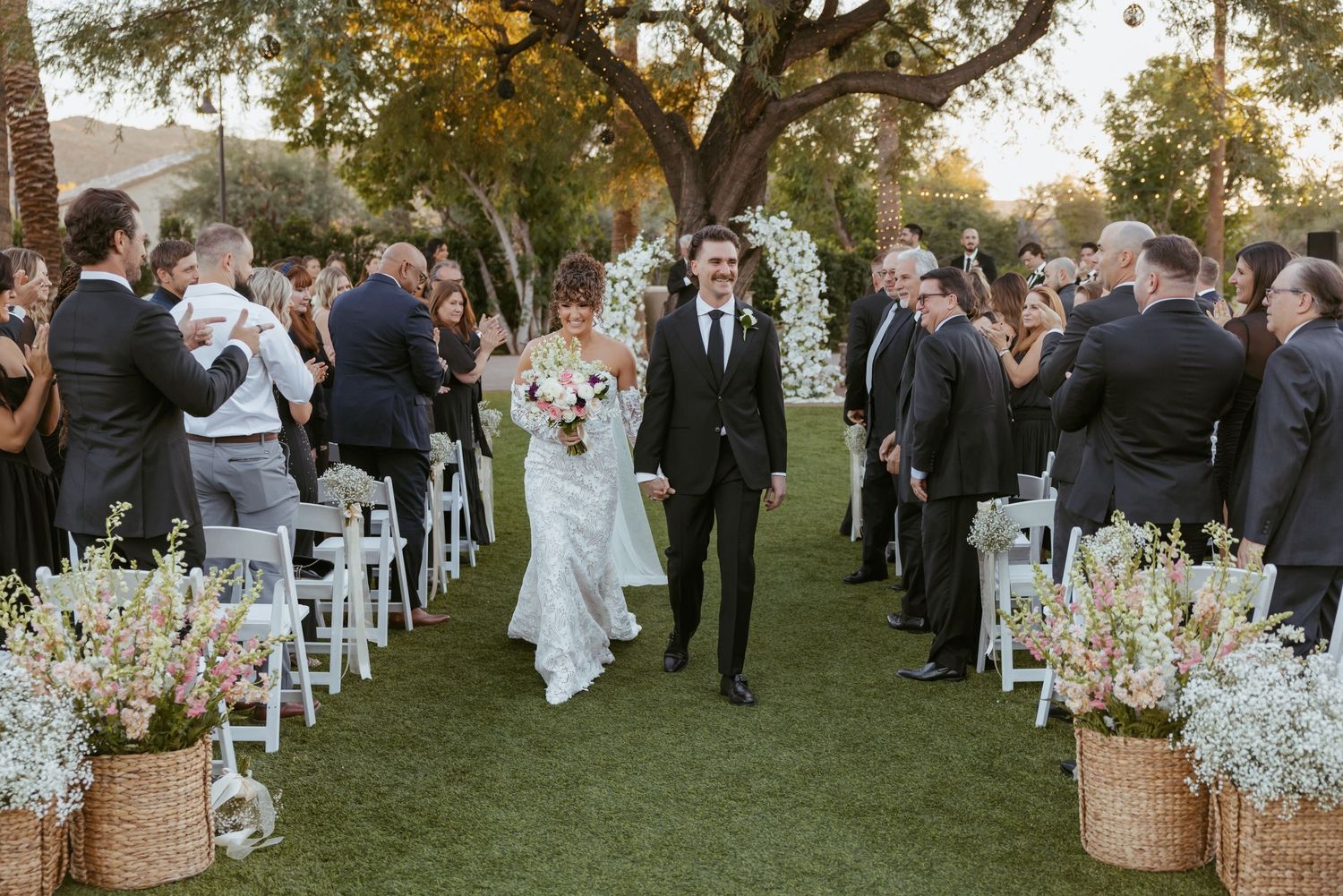 Wedding party poses for creative group photos in earth-toned attire.