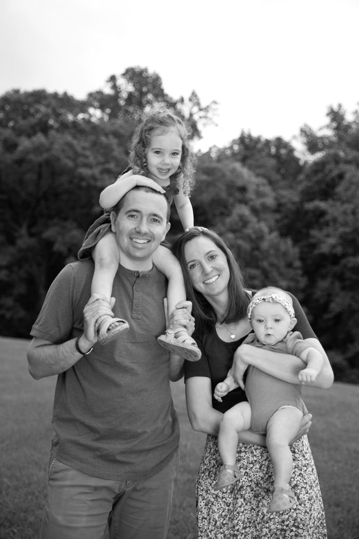 A black and white portrait of a family enjoying time together outdoors.