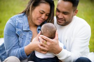 Young mother and father holding their baby and looking at her lovingly - Kelly Chapman Photographer Perth
