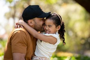 Young father kissing his young daughters cheek and in a loving embrace - Kelly Chapman Photographer Perth