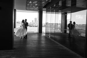 Black and white photo of a newly married couple dancing on a deck with reflection in the window - Kelly Chapman Photographer Perth