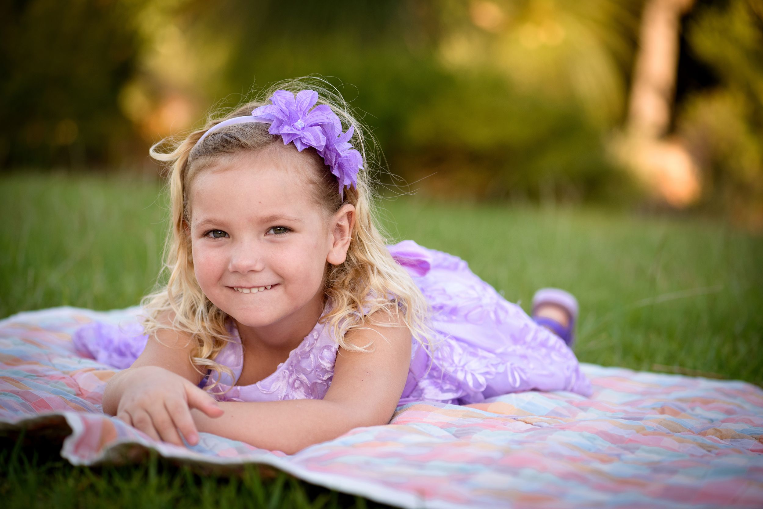 Young girl smiling for the camera and laying on a blanket - Kelly Chapman Photographer Perth