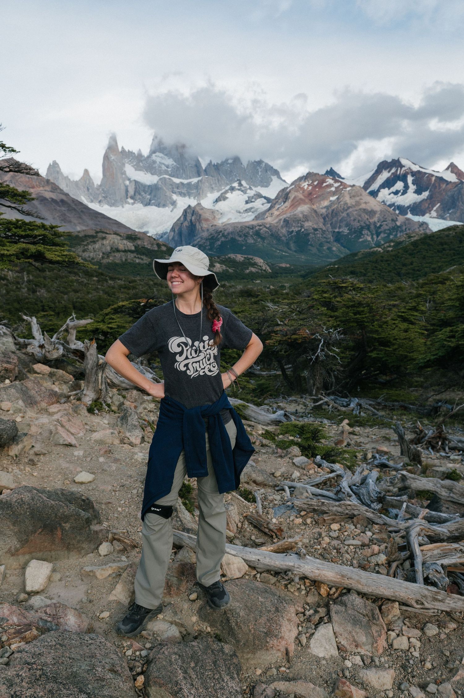 picture of smiling girl in front of mountains in a hat