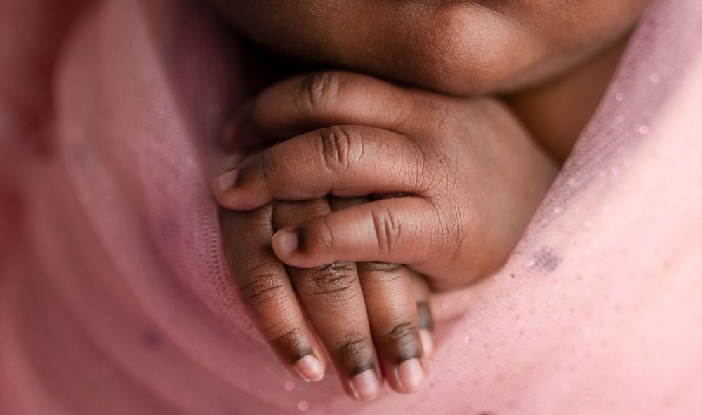 Newborn detail photography Ipswich and Brisbane – close-up of tiny hands folded on pink fabric, Springfield Lakes studio portraits for Augus