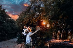 A romantic outdoor photoshoot at sunset with moody lighting and natural scenery creates a dreamy atmosphere.