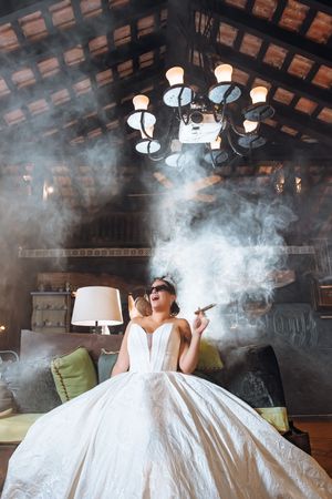 A sequence of photos showing smoke billowing around a white dress on a couch in an atmospheric indoor setting.
