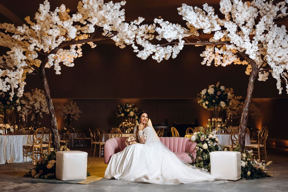 Wedding reception decor featuring elegant white cherry blossom arch and romantic lighting.