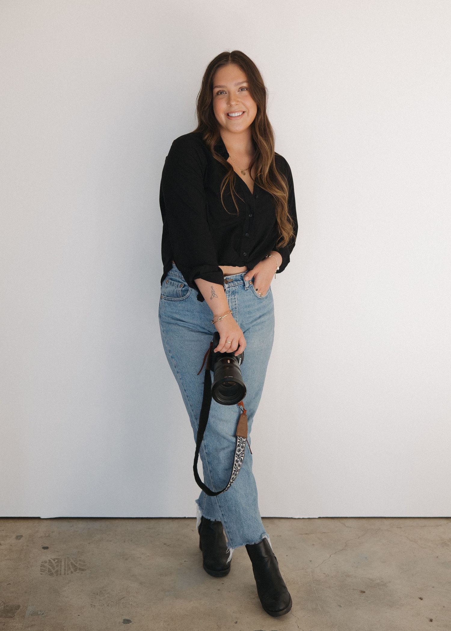 A destination wedding and portrait photographer standing in a studio in San Luis Obispo, California.