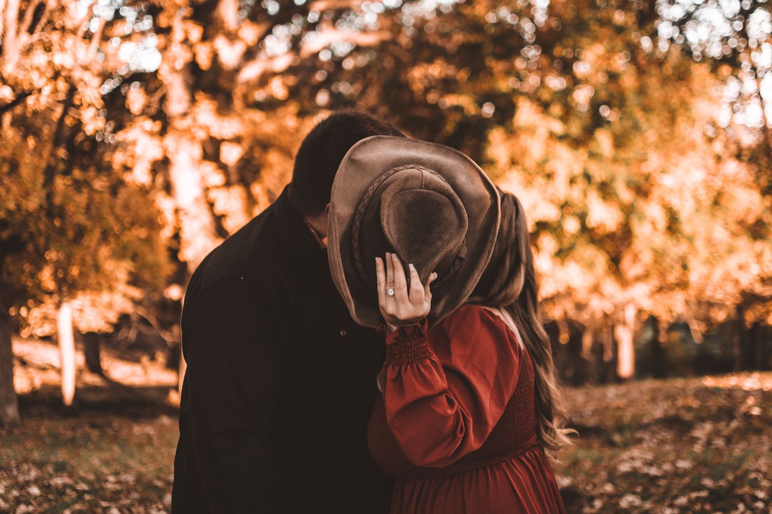 Intimate candid moment between a couple during sunset in an autumn setting.