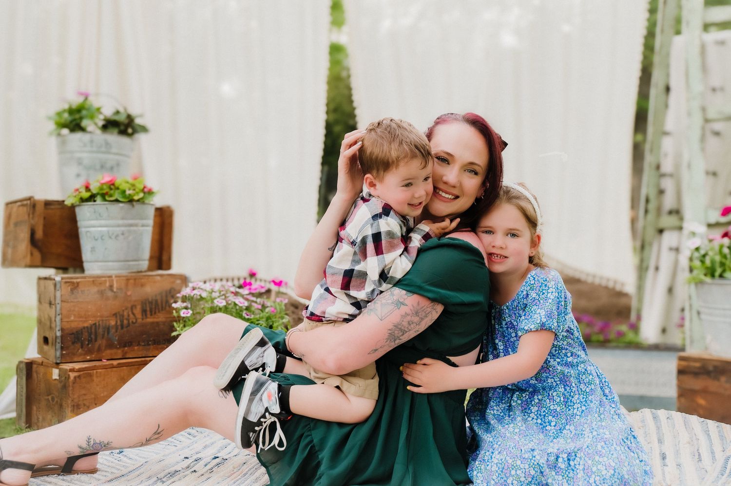 A floral dress and white dress twirl together on a picnic blanket in a sunny garden.