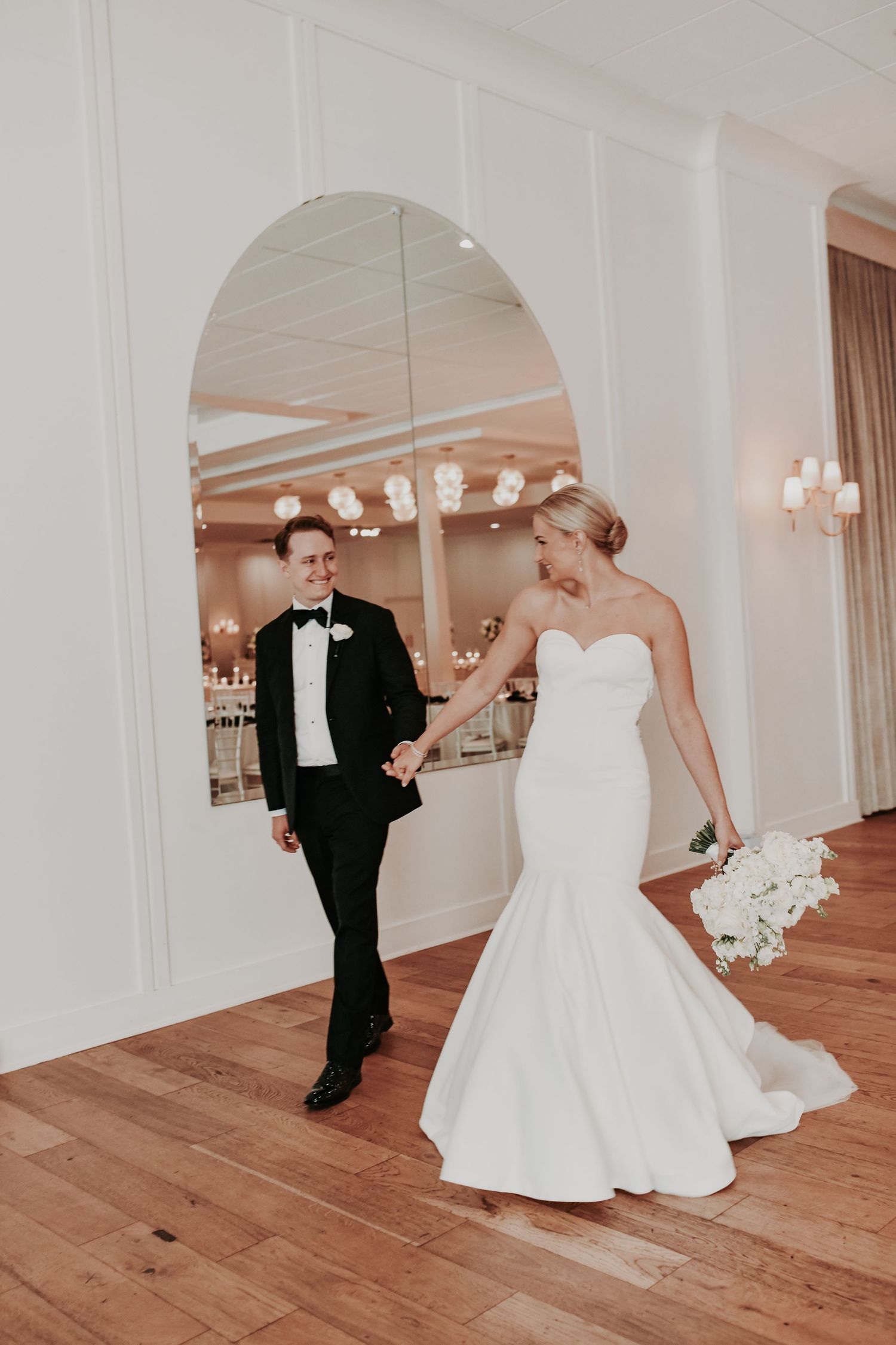 Bride and groom walk candidly into their reception