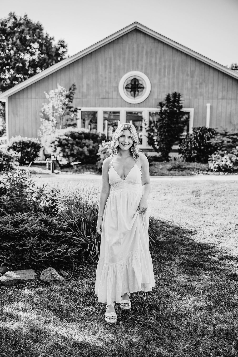 Senior girl in a yellow dress posing for senior portraits in Rochester, NY. Black and white picture.