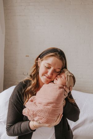 Tender family photos showing loving moments with a swaddled newborn.