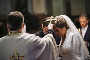 Fotografisanje venčanja u crkvi
Fotografija kako sveštenik drži krst na glavama mladenaca
