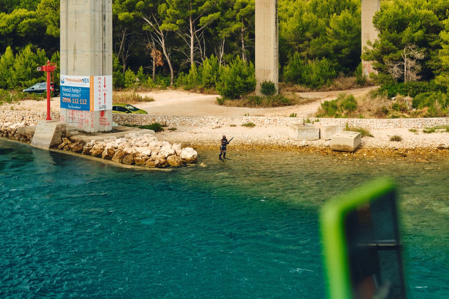 Scenic beach cove with crystal clear turquoise waters and concrete pillars.
