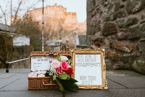 Vintage gold frames and floral decorations arranged on stone pavement with rustic wedding styling.