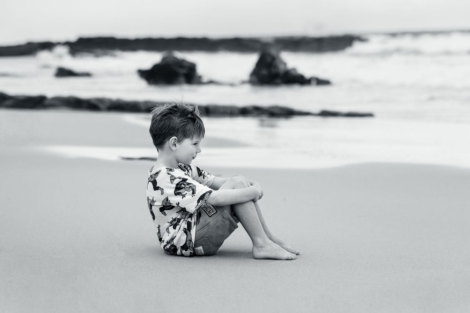 A series of black and white photographs showing people enjoying a relaxing day at a sandy beach near the ocean.