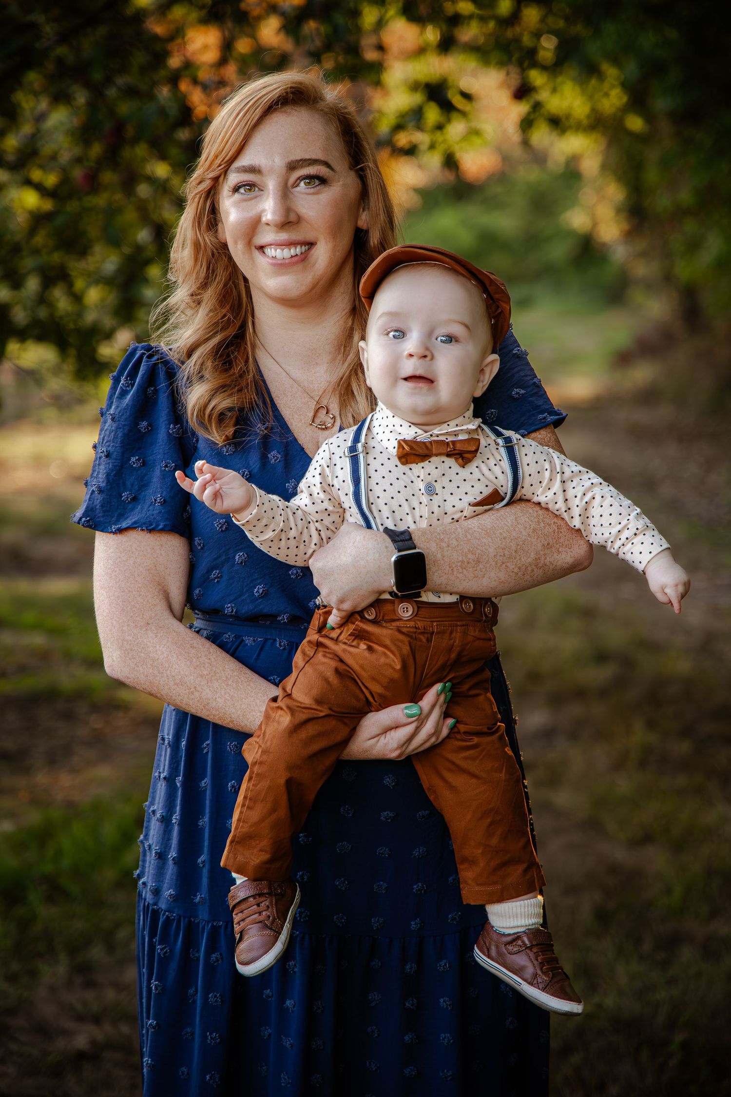 Mother and baby portrait session in autumn setting with navy dress and brown overalls.