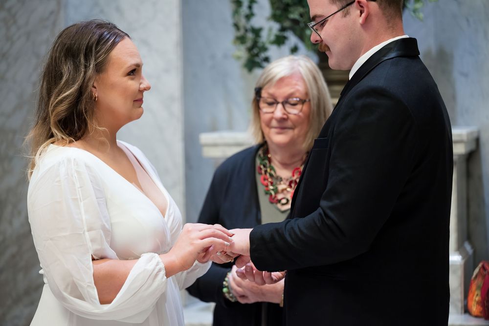 A couple exchanges rings during an intimate wedding ceremony.