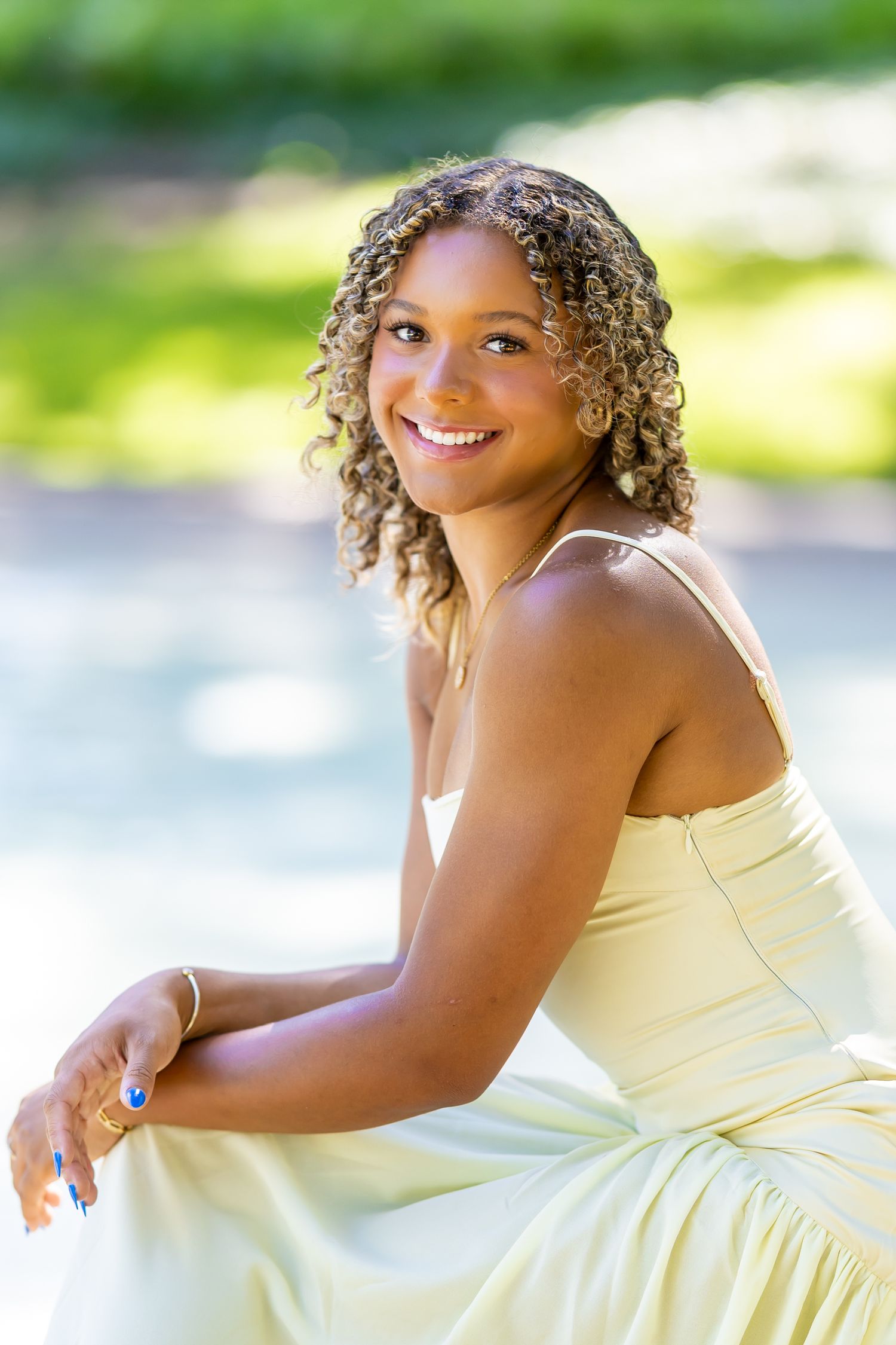 Elegant portrait session featuring a cream-colored dress against a waterfront background.