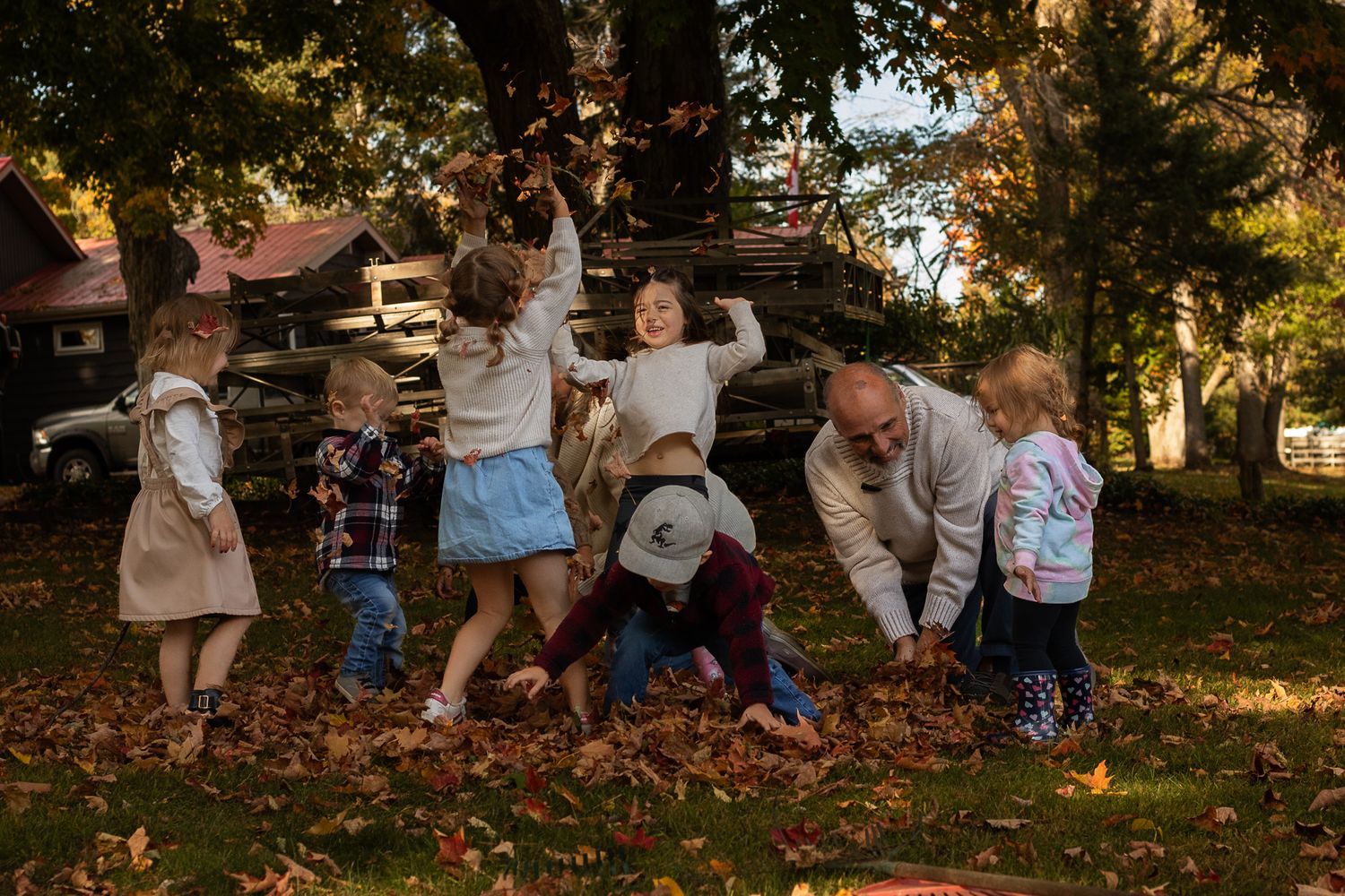 grandparents and grandkids playing in the leaves