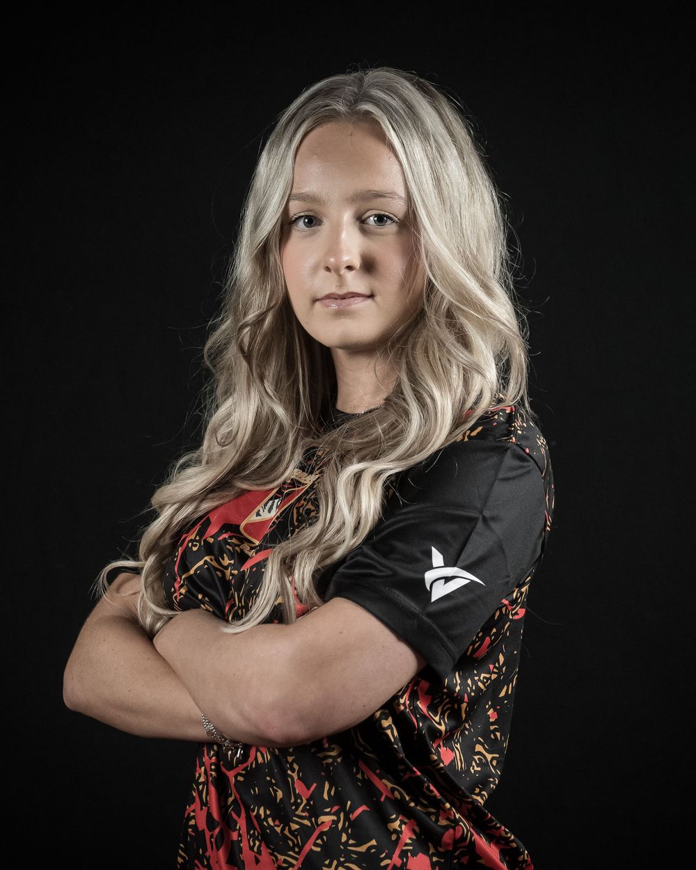 A figure in a black and red floral dress poses against a dark background in a series of dramatic studio portraits.
