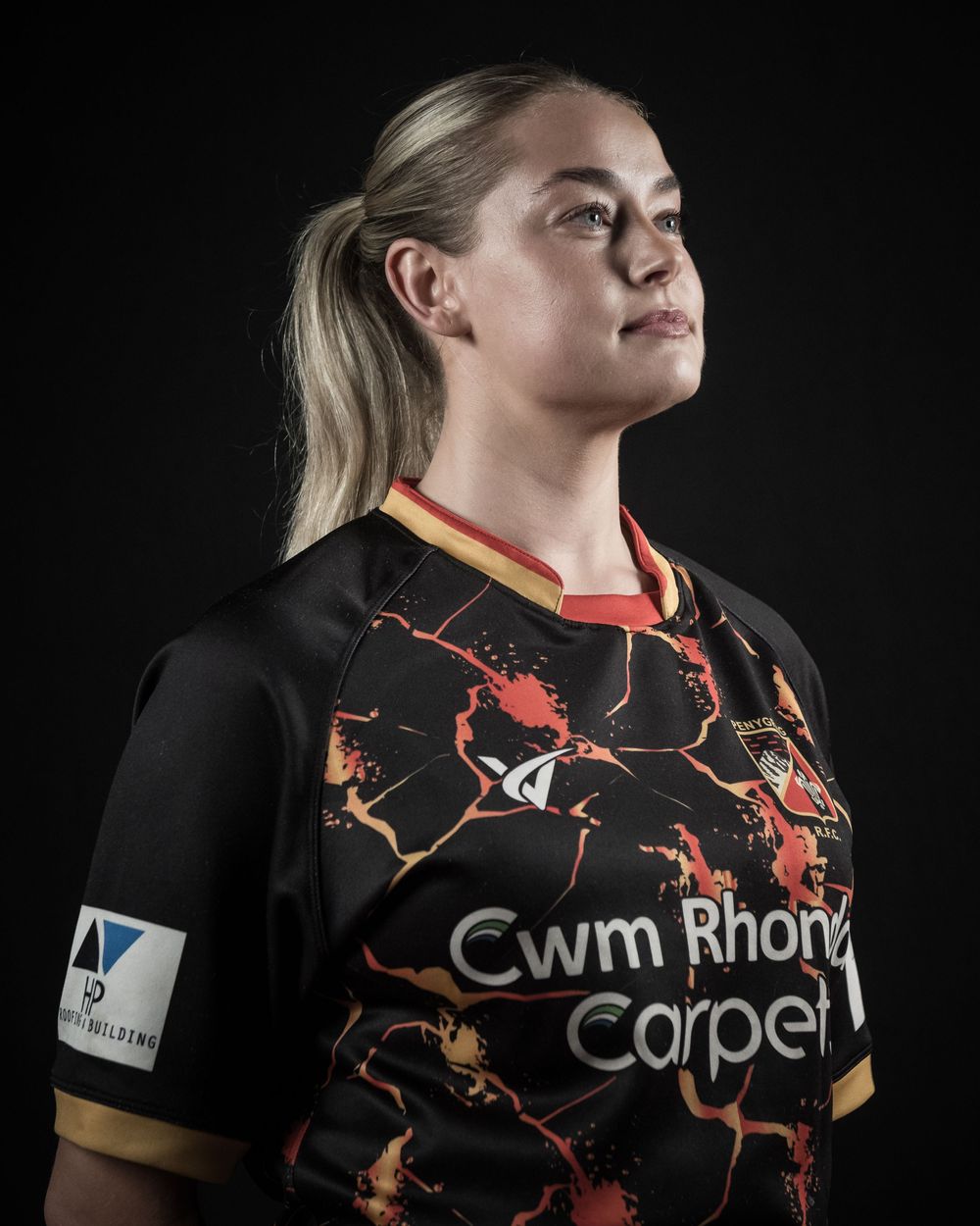 Black and orange rugby jersey with lava-like pattern design shown from multiple angles against dark background.